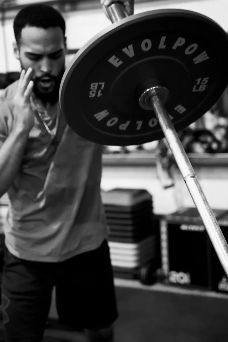Jeremiah with a loaded barbell on his shoulder