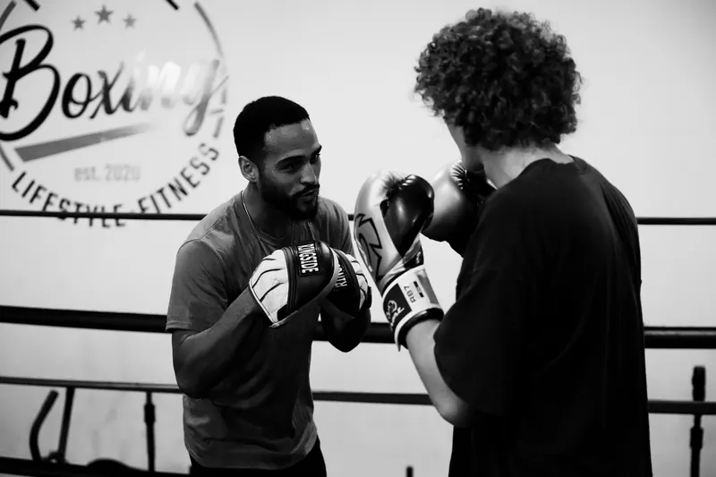 Jeremiah running pad work with a client in the ring